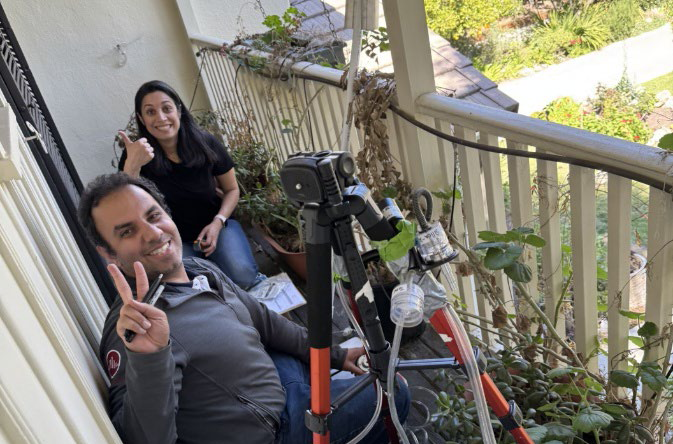 Researchers from the LA Fire HEALTH Study team take air quality measurements on a home balcony.