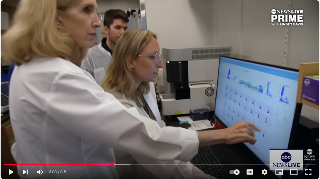 Kari Nadeau and research assistants looking at a lab reading on a computer screen.